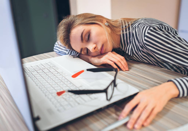 freelancer chica durmiendo en el trabajo en la mesa cerca de la laptop
 - Foto, Imagen