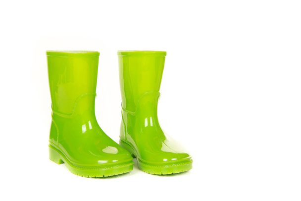 Botas de lluvia infantiles brillantes verdes sobre un fondo blanco
 - Foto, Imagen