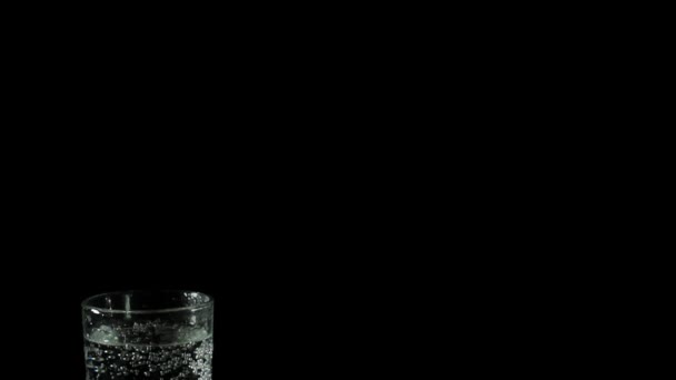 Frisse mineraalwater in een glas op zwarte achtergrond - Video