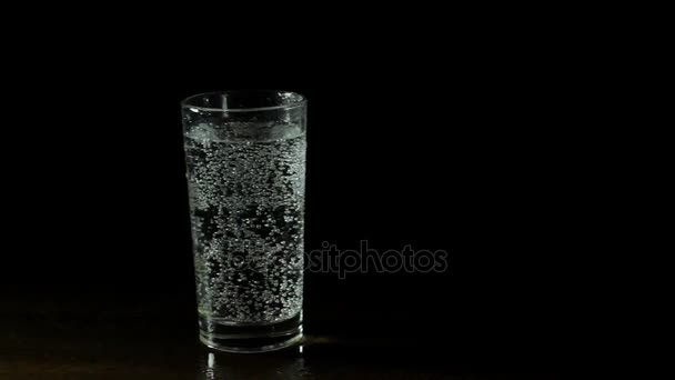 Fresh mineral water in a glass on black background - Video