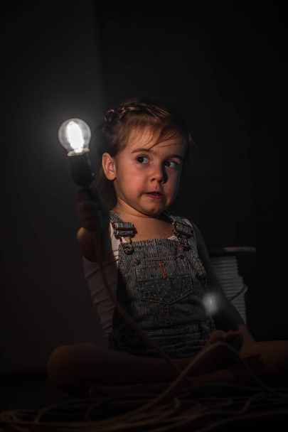 menina bonito com lâmpada na mão
 - Foto, Imagem