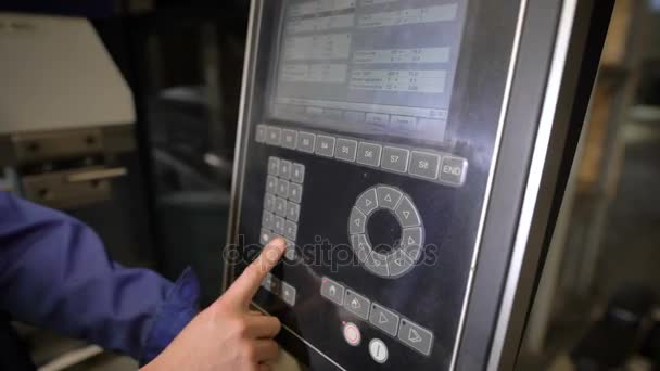 労働者は、数値プログラム制御で工作機械のパネルのボタンを押した。技術者が機械を操作するためのプログラムを構成します. - 映像、動画