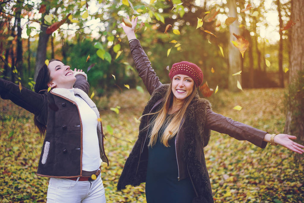 Two cute young woman celebrating autumn - Photo, Image