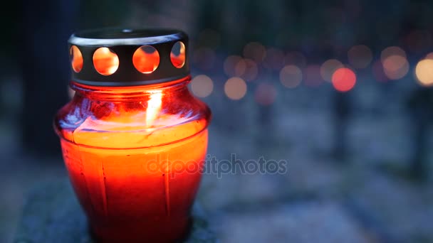 Hautausmaa yöllä värikkäitä kynttilöitä Pyhäinpäivä. Pyhäinpäivä on katolisen kirkon 1. marraskuuta viettämä juhlapäivä. Staattinen laukaus
. - Materiaali, video
