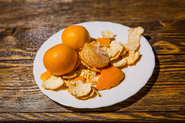 Tangerines lie on a white dish - Zdjęcie, obraz