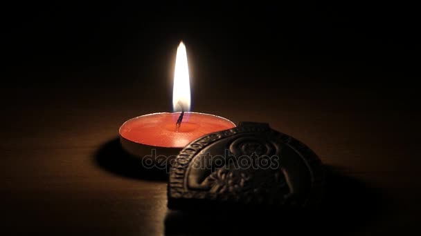 una vela Votiva Lit de pie cerca de un icono de madera de Santa María en la noche
. - Imágenes, Vídeo