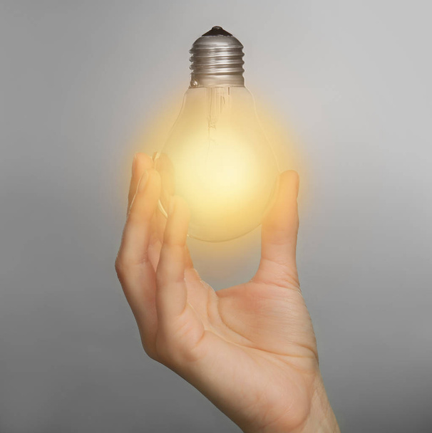 Woman holding light bulb   - Foto, imagen