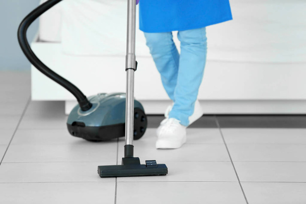 woman hoovering floor with vacuum cleaner - Fotoğraf, Görsel