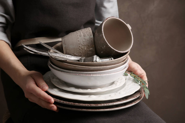 hands holding pile of dish ware - Фото, изображение