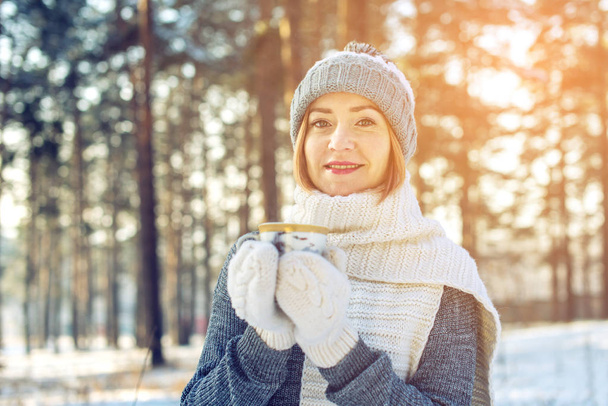 donna attraente in inverno bere tè caldo alla luce del sole
 - Foto, immagini