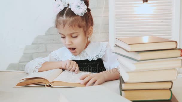 Bir tablo ve okuma oturan kız öğrenci bu esner okuma sırasında bir kitap. - Video, Çekim