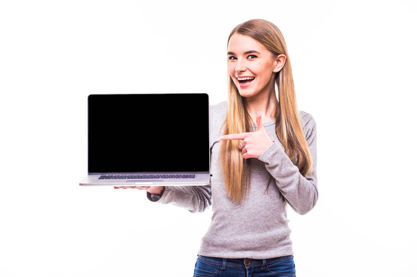 Blondes Mädchen zeigte auf Bildschirm von Laptop auf weiß - Foto, Bild