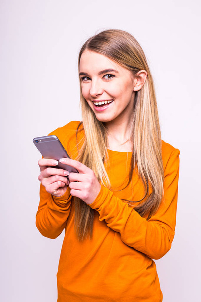 Happy girl text sms on phone - Valokuva, kuva