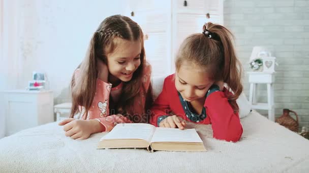 Два маленьких друга в пижаме и читают книги. Они говорят и обсуждают книгу
. - Кадры, видео