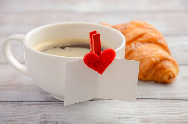 Cup of fresh morning coffee with croissant. Valentine's day concept. - Photo, Image