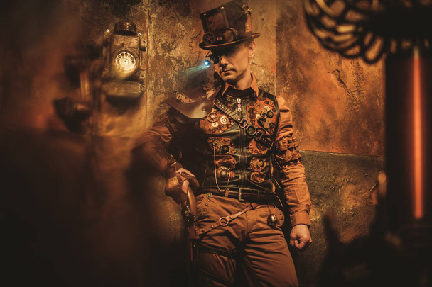 Portrait of steampunk man with various mechanical devices on vintage steampunk background - Photo, Image