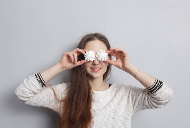 Menina fechando os olhos com merengues
 - Foto, Imagem