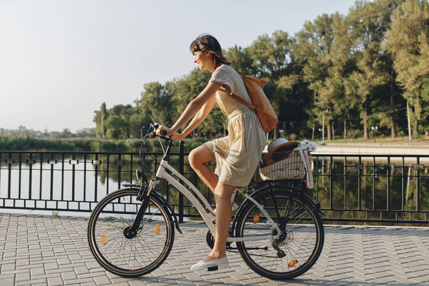 Молода жінка на фоні природи з велосипедом
 - Фото, зображення