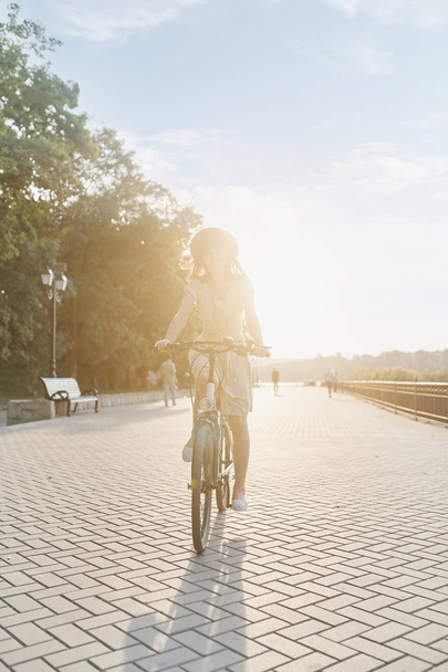 Молодая женщина на фоне природы с велосипедом
 - Фото, изображение