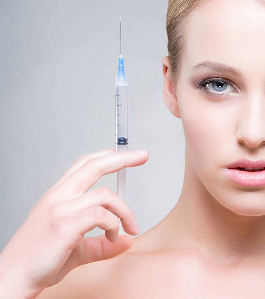  young woman holding syringe - Foto, imagen