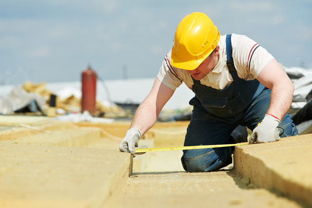 Roofer worker measuring insulation material - Foto, Bild