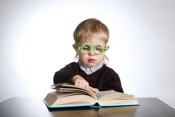 boy in funny glasses reading book on white - Photo, Image