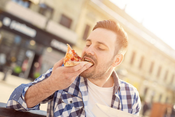 Homme mangeant de la pizza
 - Photo, image