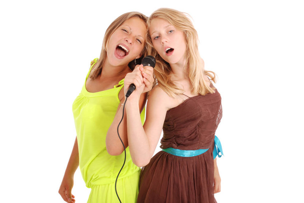 Дві красиві співачки-підлітки співають з мікрофоном
 - Фото, зображення