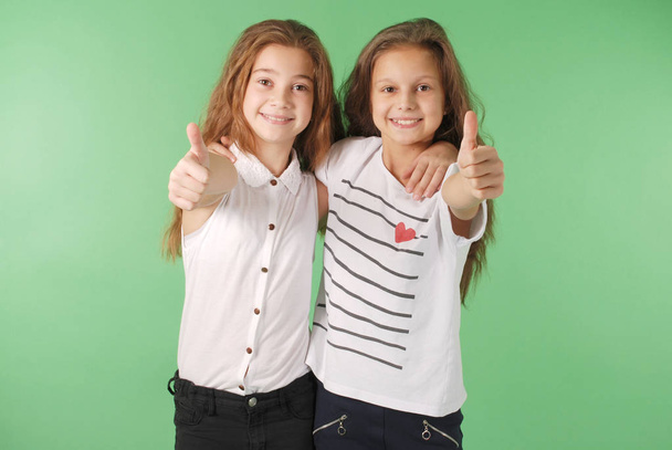 Két mosolygó fiatal iskolás lányok remek felbukkan - Fotó, kép