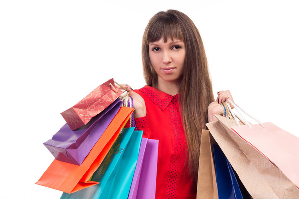 Young long-haired woman holds shopping purchases, many multicolo - Photo, Image
