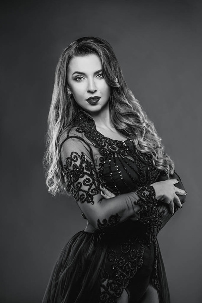 Jeune belle femme aux cheveux longs attrayant et chaud en sous-vêtements noirs sur fond gris en studio photo
 - Photo, image
