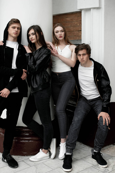 Молоді елегантні модні друзі на відкритому повітрі, одягнені в чорно-білий одяг
 - Фото, зображення