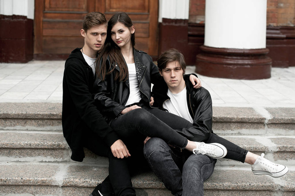 Jonge elegante trendy vrienden buitenshuis, zwarte en witte kleding dragen - Foto, afbeelding