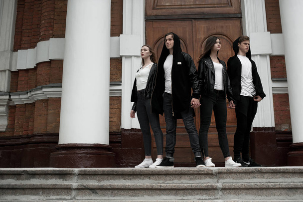 Young elegant trendy friends outdoors, wearing black and white clothing - Foto, imagen