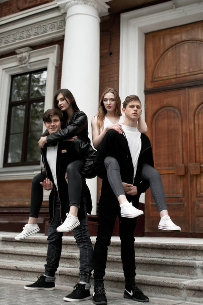 Giovani eleganti amici alla moda all'aperto, vestiti in bianco e nero
 - Foto, immagini