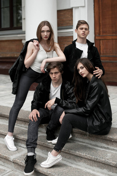 Молоді елегантні модні друзі на відкритому повітрі, одягнені в чорно-білий одяг
 - Фото, зображення
