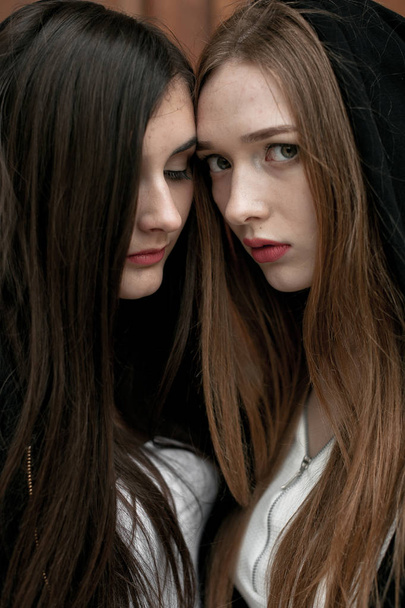 Young elegant trendy girls outdoors, wearing black and white clothing - Photo, Image