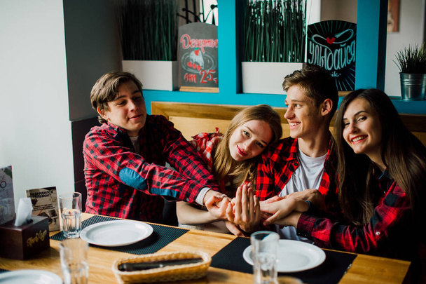 Group of young friends hanging out at a coffee shop. Young men and women meeting in a cafe having fun and drinking coffee. Lifestyle, friendship and urban life concepts. - Photo, Image