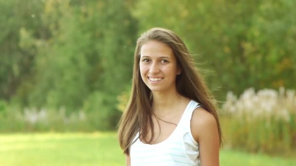 krásná mladá žena dlouhé vlasy-bruneta pozadí letní park s úsměvem hospodářství citron - Záběry, video