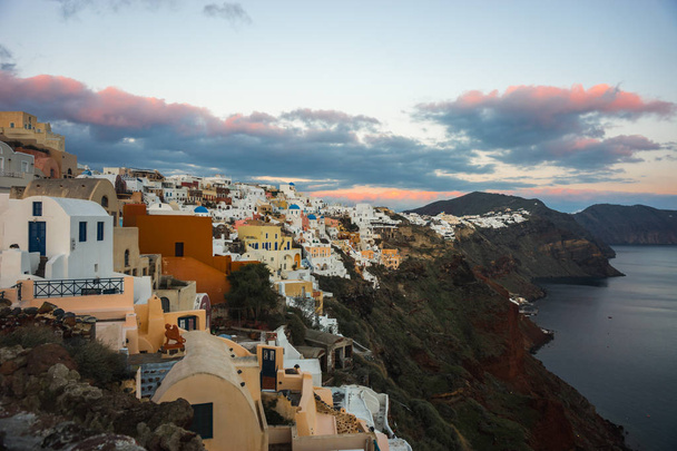 White city on a slope of a hill at sunset, Oia, Santorini, Greec - Zdjęcie, obraz