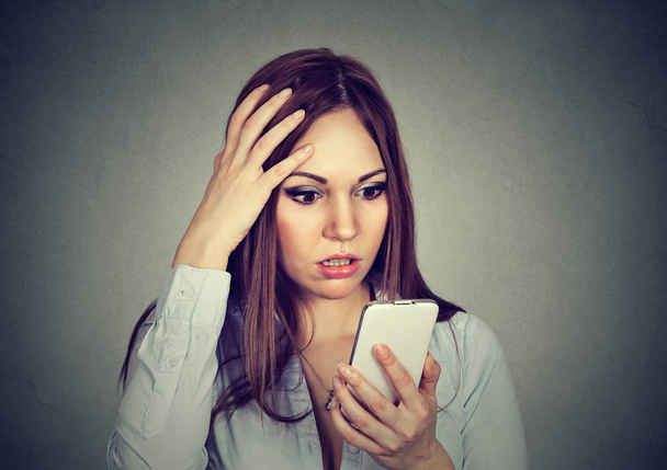 Upset woman looking at cellphone worried with message she received - Photo, Image
