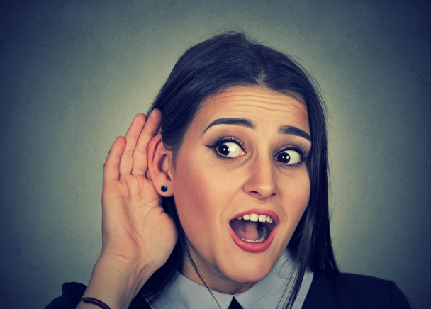 Femme surprise avec la main à l'oreille à l'écoute de commérages conversation
  - Photo, image