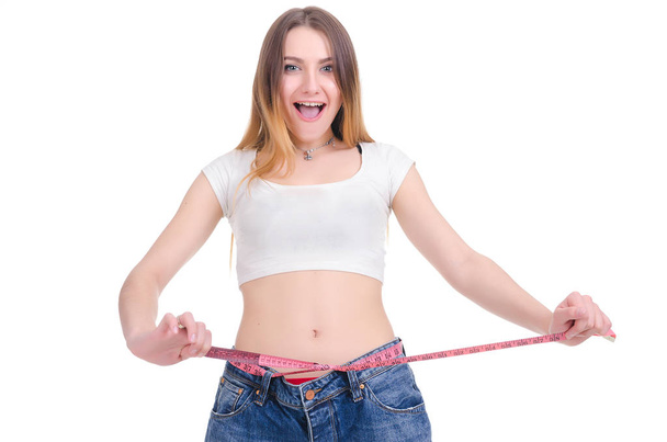  Diet. Fitness. Young Girl in blue jeans large size on a white background - Фото, зображення