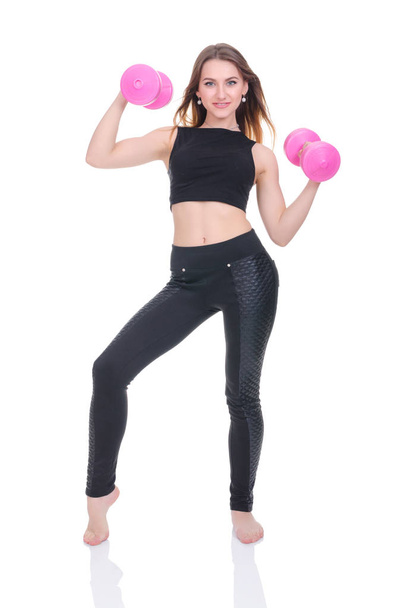  Diet. Fitness. Young beautiful girl with pink dumbbells in his hands. Girl performs sporting exercise - Foto, Imagen