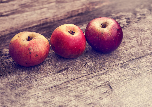 Rode appels op houten tafel - Foto, afbeelding