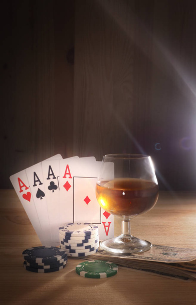 Glass with a alcohol , playing cards . wooden background - 写真・画像
