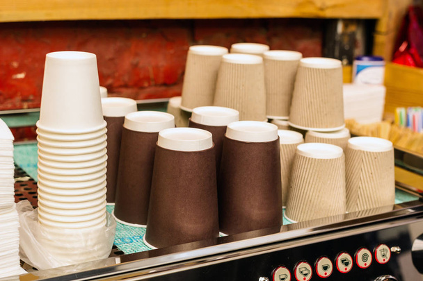 Une machine à café avec une grande pile de tasses en papier à côté
. - Photo, image