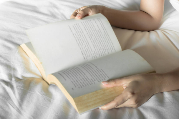 Женщина читает книгу на кровати, избирательный фокус
 - Фото, изображение