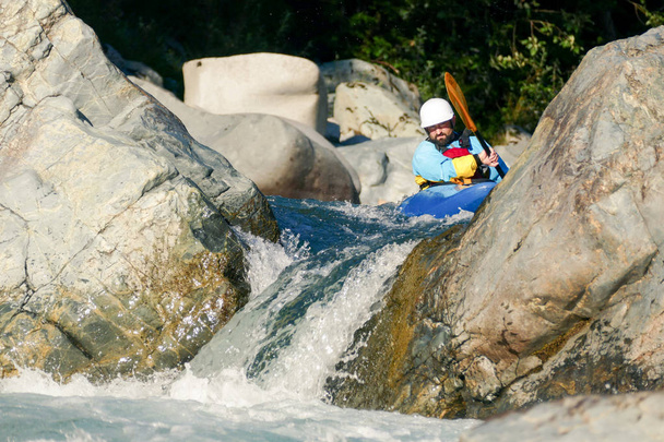 Ο άνθρωπος στην Kayak αντιμετωπίζει βραχώδης ορμητικά κωπηλασία προς καταρράκτη σταγόνα - Φωτογραφία, εικόνα