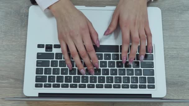 Ilmakuva naisesta kirjoittamassa kannettavalla tietokoneella. Sijoitettu puiselle pöydälle - Materiaali, video
